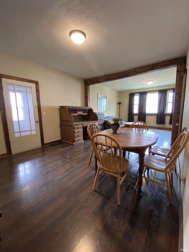 dining room featuring baseboards and dark wood finished floors