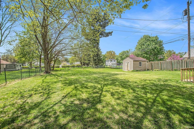 view of yard featuring an outdoor structure, a fenced backyard, and a storage unit