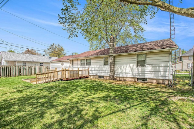 back of house featuring a lawn and a fenced backyard