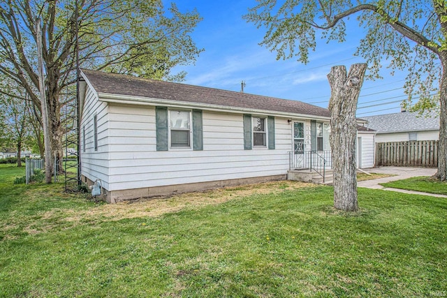 ranch-style home with a front lawn and fence