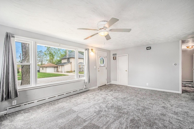 carpeted spare room featuring a ceiling fan, baseboards, a baseboard heating unit, and a textured ceiling