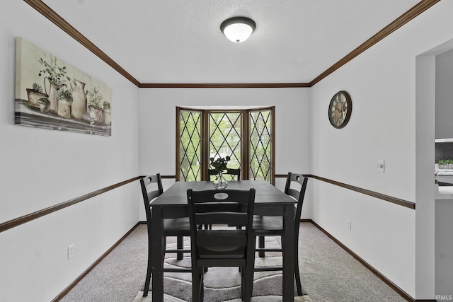 carpeted dining area featuring baseboards, ornamental molding, and a textured ceiling