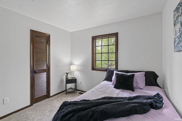 carpeted bedroom with baseboards and a textured ceiling