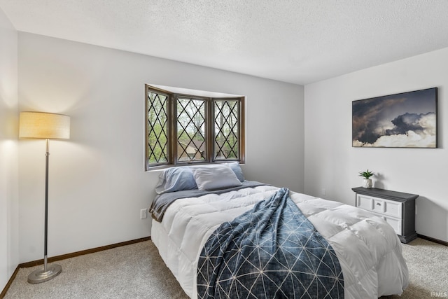carpeted bedroom featuring baseboards and a textured ceiling