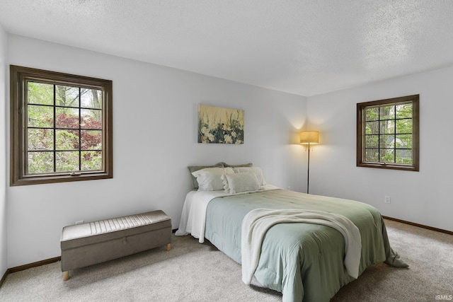 carpeted bedroom featuring baseboards and a textured ceiling