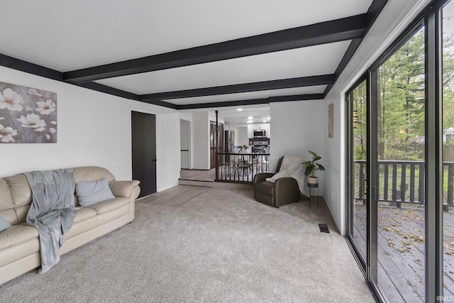 living area with carpet, beamed ceiling, and visible vents