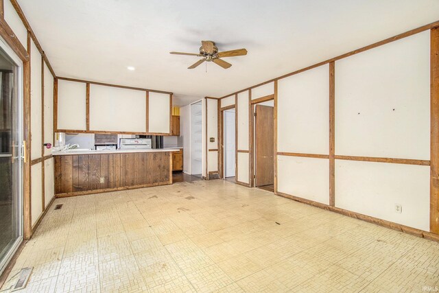 kitchen featuring a peninsula, light floors, ceiling fan, light countertops, and white cabinets