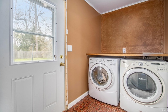 washroom featuring laundry area, crown molding, brick patterned floor, baseboards, and separate washer and dryer