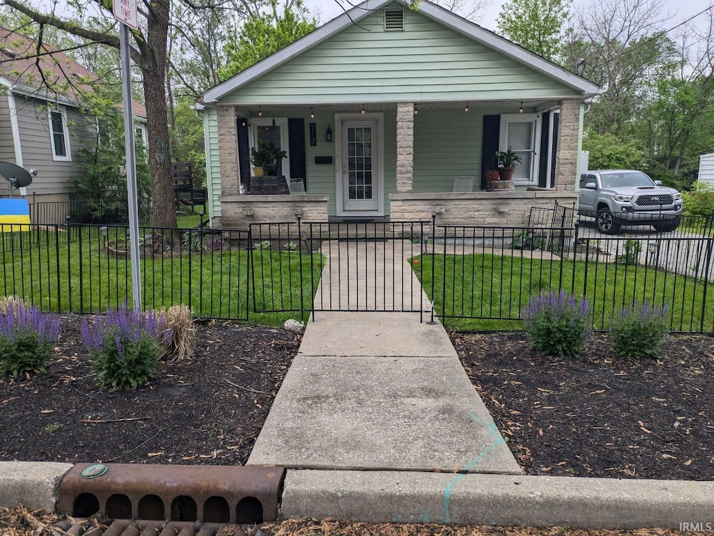 bungalow featuring a gate, a fenced front yard, a porch, and a front lawn