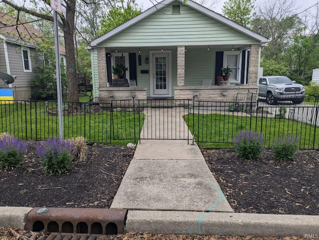 bungalow featuring a gate, a fenced front yard, a porch, and a front lawn