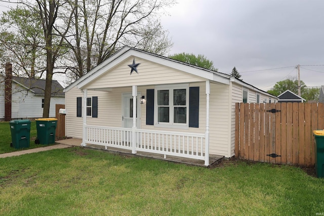 view of front facade featuring fence, a porch, and a front lawn
