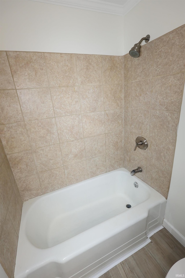 full bathroom with crown molding, baseboards, washtub / shower combination, and wood finished floors