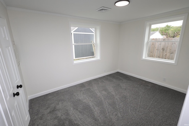 unfurnished room with dark carpet, ornamental molding, baseboards, and visible vents