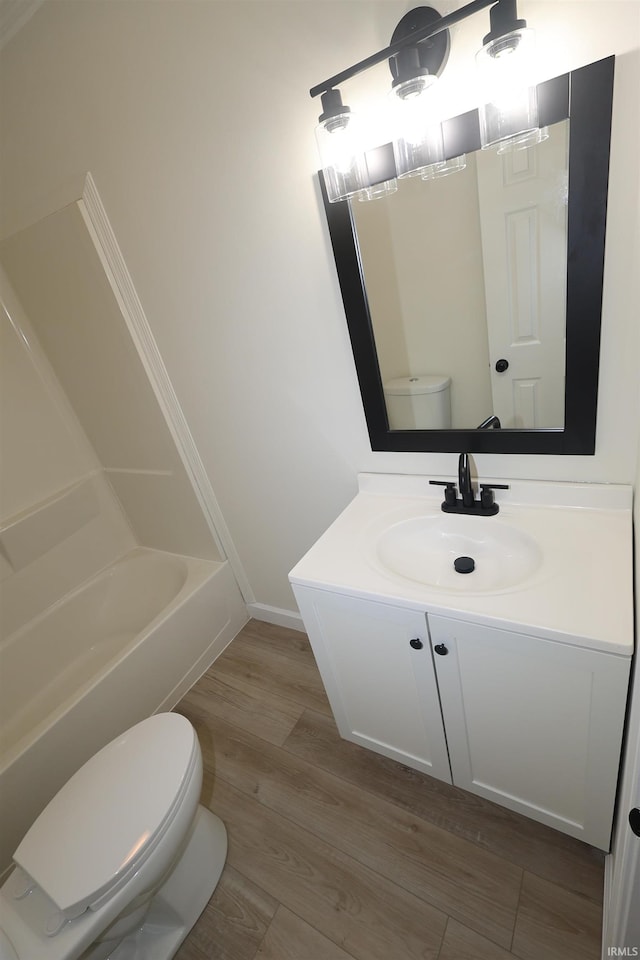 bathroom with vanity, baseboards, toilet, and wood finished floors