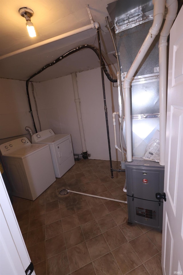 below grade area featuring separate washer and dryer and dark tile patterned flooring