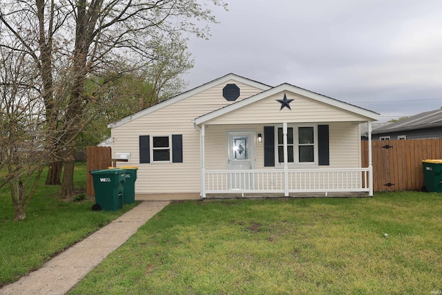 bungalow-style house featuring a porch, fence, and a front yard