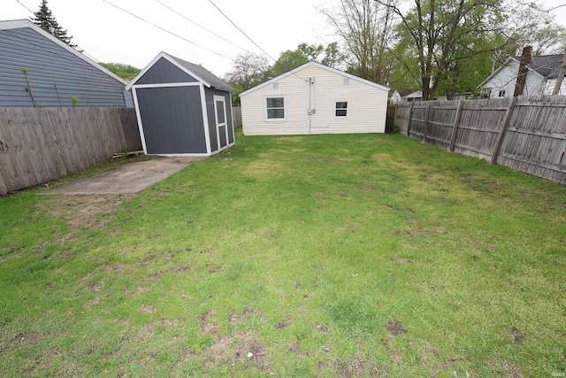 view of yard featuring an outdoor structure, a fenced backyard, and a shed