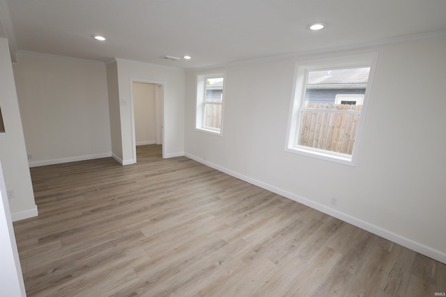 empty room with recessed lighting, baseboards, ornamental molding, and light wood finished floors