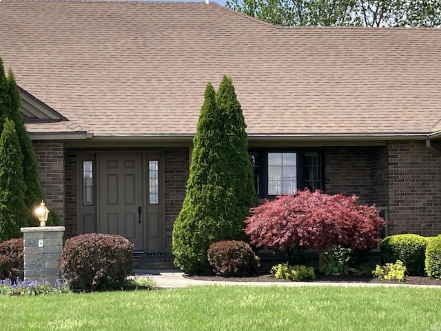760 N 700 E, Bluffton, IN 46714 - view of exterior entry with brick siding, roof with shingles, and a yard