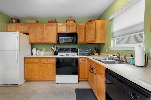 kitchen featuring light countertops, a sink, black appliances, and a toaster