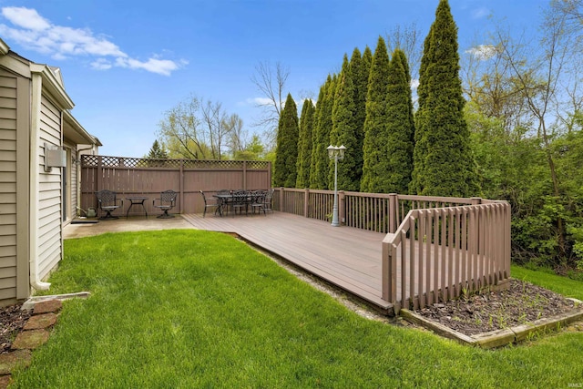 view of yard with fence, outdoor dining space, and a deck