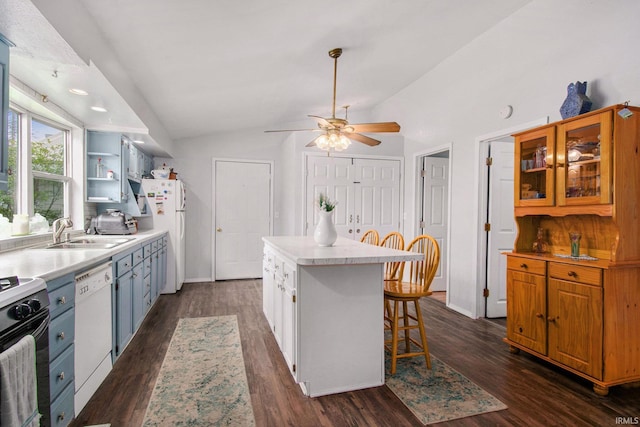 kitchen with a breakfast bar, a sink, white appliances, lofted ceiling, and a kitchen island