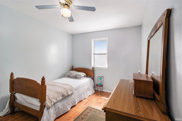 bedroom featuring baseboards, a ceiling fan, and light wood finished floors