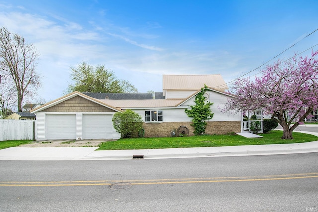 view of front of house featuring fence, concrete driveway, a front yard, and a garage