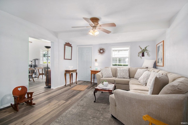 living area featuring baseboards, a ceiling fan, and wood finished floors