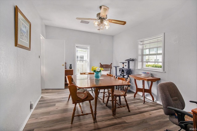 dining room featuring visible vents, a ceiling fan, baseboards, and wood finished floors