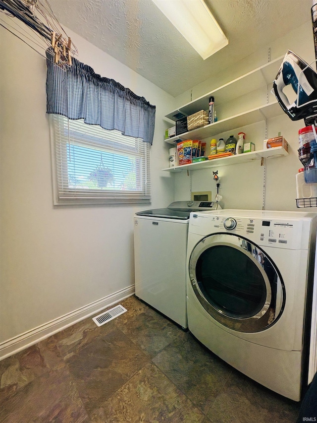 3701 Wethersfield Dr, Evansville, IN 47725 - clothes washing area with washer and dryer, baseboards, a textured ceiling, and stone finish flooring