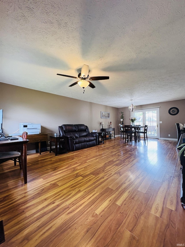 3701 Wethersfield Dr, Evansville, IN 47725 - living area featuring a textured ceiling, light wood-style flooring, ceiling fan, and a chandelier