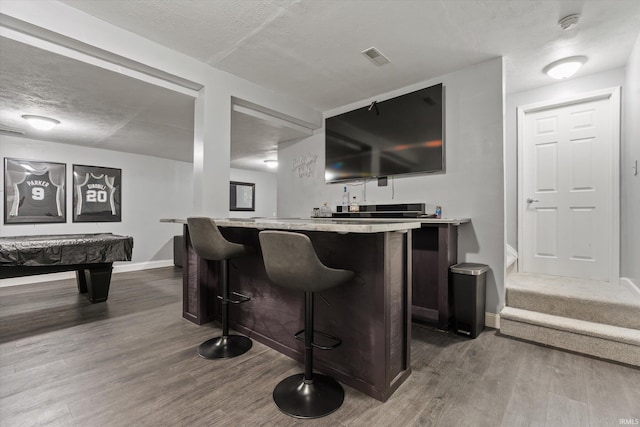 29930 Prairieview Farms Blvd, Elkhart, IN 46514 - bar featuring indoor wet bar, a textured ceiling, dark wood-style flooring, and baseboards