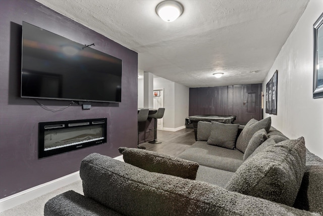 29930 Prairieview Farms Blvd, Elkhart, IN 46514 - home theater featuring a textured ceiling, a glass covered fireplace, baseboards, and wood finished floors