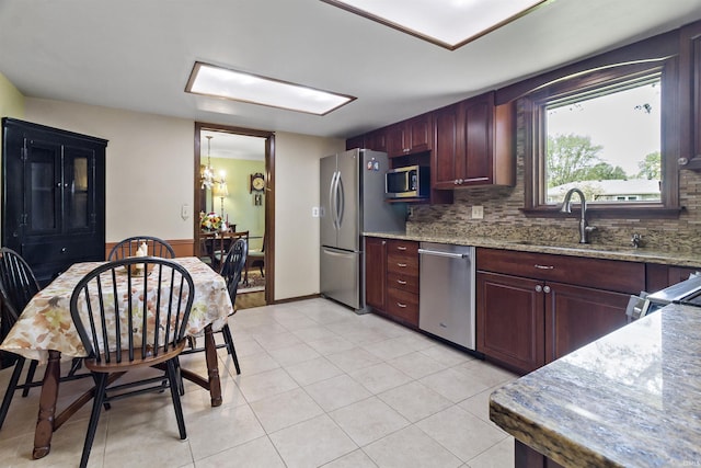 4231 N Conner Dr, Marion, IN 46952 - kitchen featuring light stone countertops, appliances with stainless steel finishes, a sink, light tile patterned floors, and backsplash