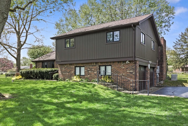 4231 N Conner Dr, Marion, IN 46952 - view of front facade with a front lawn, brick siding, a garage, central AC unit, and driveway