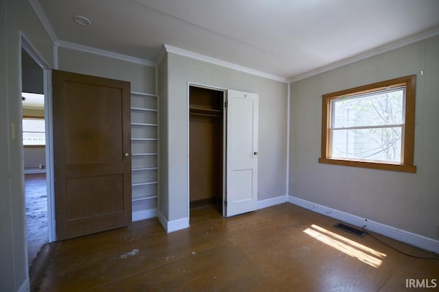 unfurnished bedroom featuring visible vents, ornamental molding, baseboards, and wood finished floors