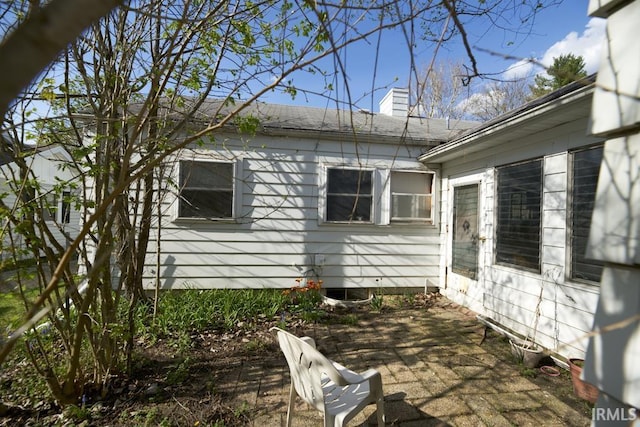 view of side of property with a chimney and a patio area