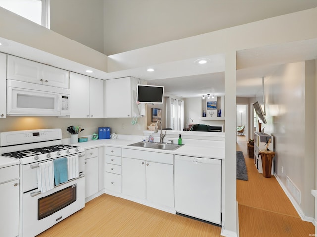 kitchen featuring a sink, light wood-style floors, white appliances, light countertops, and visible vents