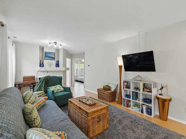 living area with baseboards and wood finished floors