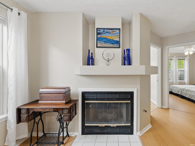 interior details with baseboards, a glass covered fireplace, and wood finished floors