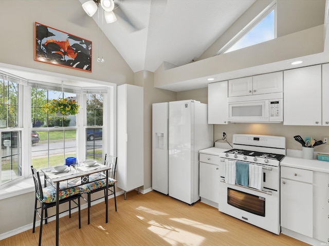 kitchen featuring light wood-type flooring, light countertops, and white appliances