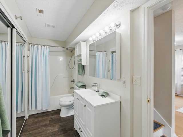 full bathroom with toilet, visible vents, wood finished floors, and vanity