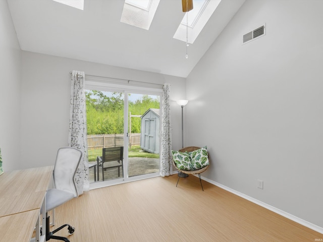 office space featuring high vaulted ceiling, baseboards, wood finished floors, a skylight, and visible vents