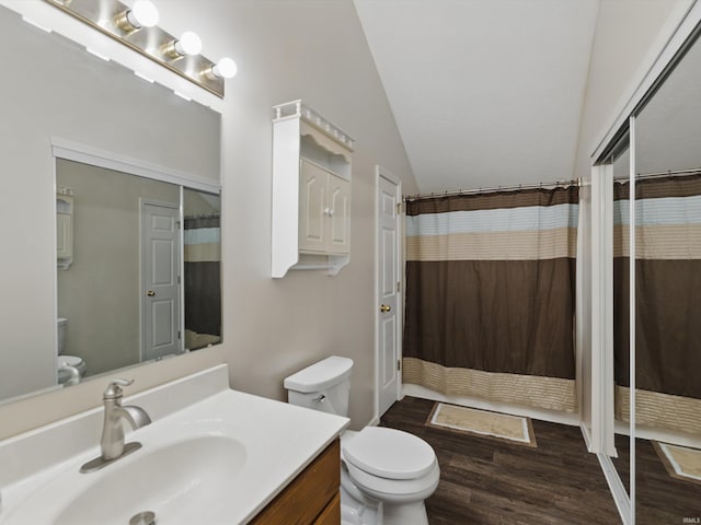 bathroom featuring vanity, wood finished floors, curtained shower, toilet, and vaulted ceiling
