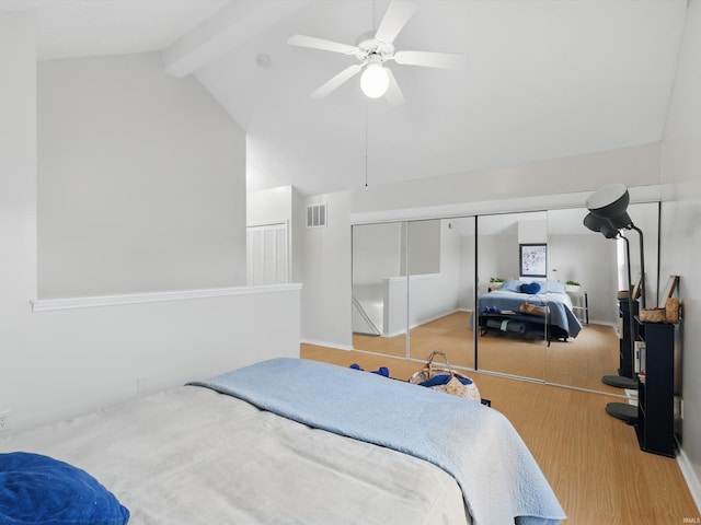 bedroom with high vaulted ceiling, wood finished floors, beamed ceiling, visible vents, and a closet