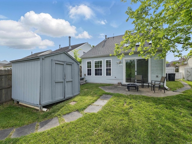 back of house with a yard, a patio, fence, and a storage unit