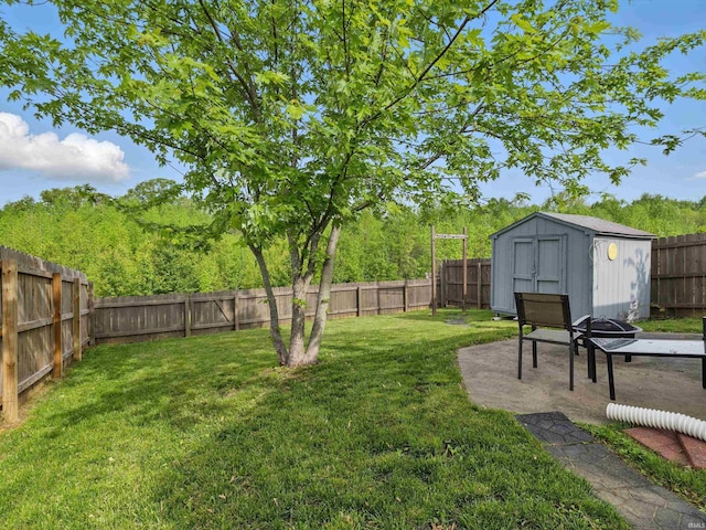 view of yard with an outdoor structure, a fenced backyard, and a storage unit