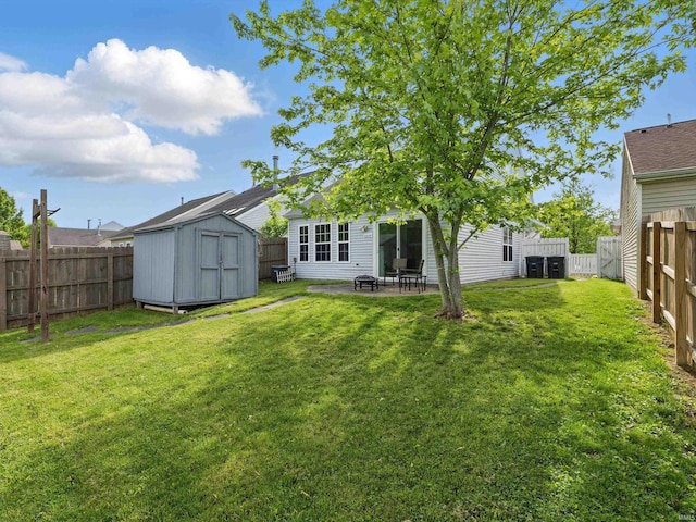 view of yard with a patio, a fenced backyard, and a storage shed