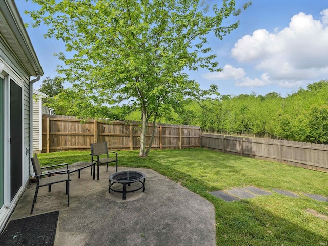 view of yard with a fenced backyard, a fire pit, and a patio area